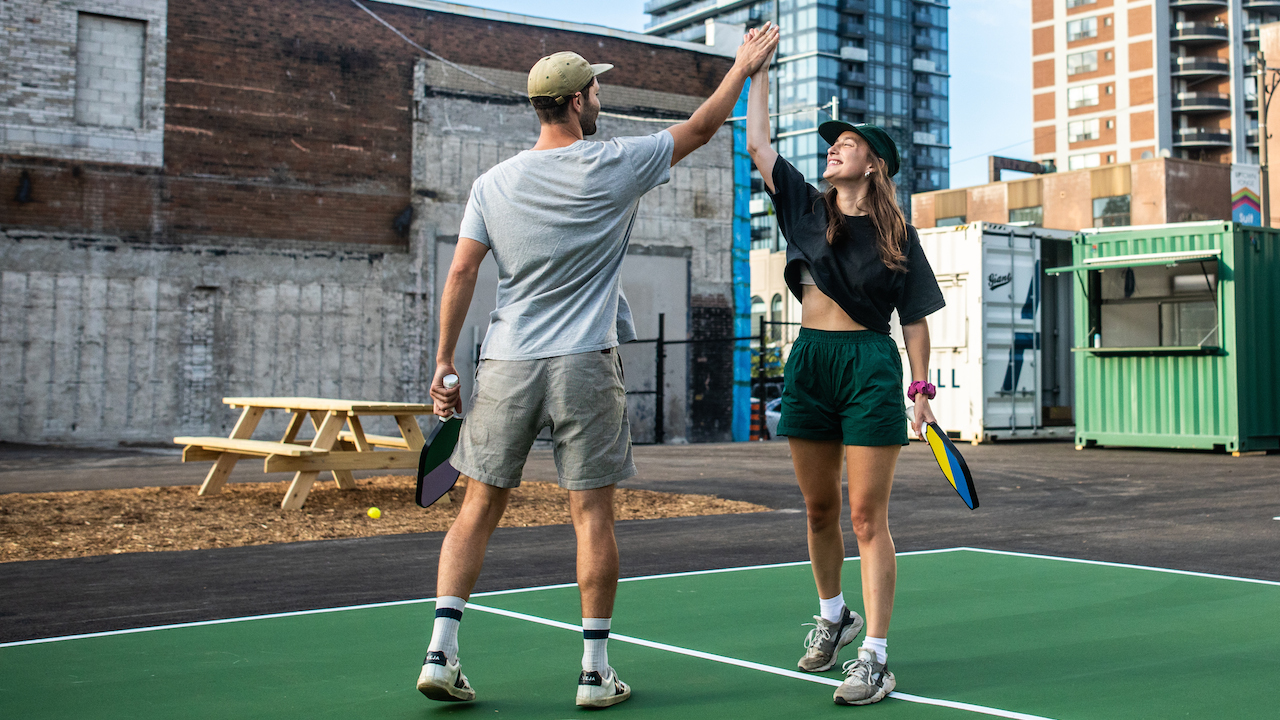 Pickleball players high-fiving after a match